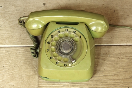 Old green vintage telephone on the tableの写真素材