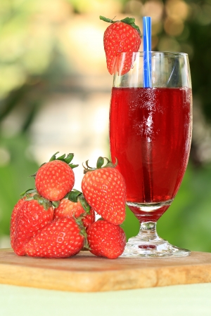 Glass with Liqueur and fresh strawberry juice on the table の写真素材