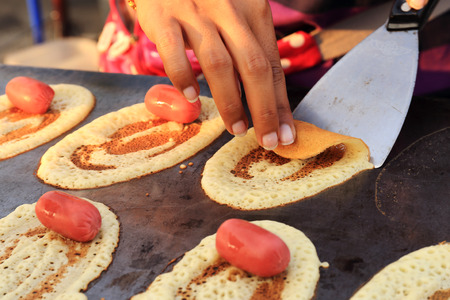 Making sausage crepes Thai style in the market