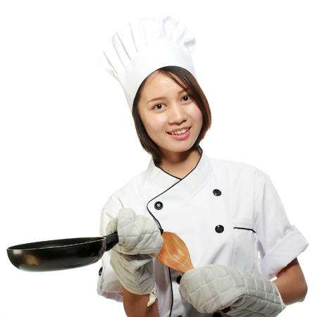 Young and happy beautiful girl preparing lunch   Young and happy beautiful girl cooking isolated on white background の写真素材
