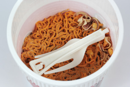 Instant noodles and plastic fork in the cup
