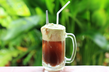 Root beer float a tasty summer treat on Green tree backgroundの写真素材