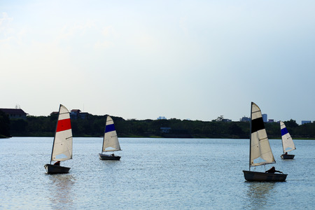 The Sailboats on a pond against a white and dark sky