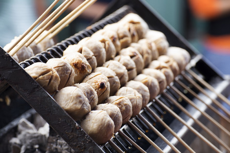 Thai meat ball with bamboo stick on the stove    selective focusの写真素材