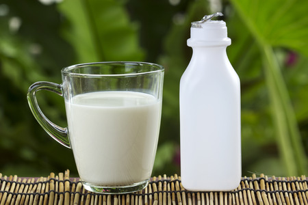Glass of Fresh Milk and bottle on the table の写真素材