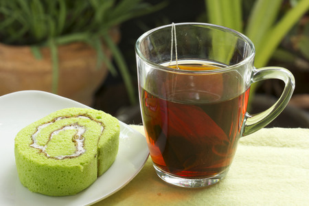 slice Roll pandan flavored cake with hot teaの写真素材