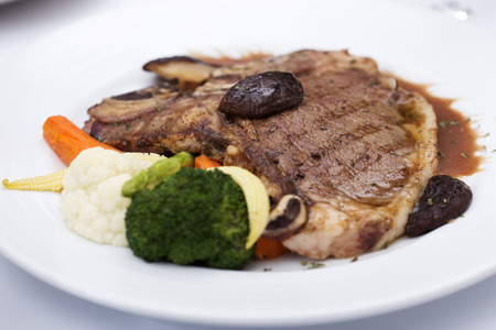 grilled t-bone steak and vegetables on the tableの写真素材