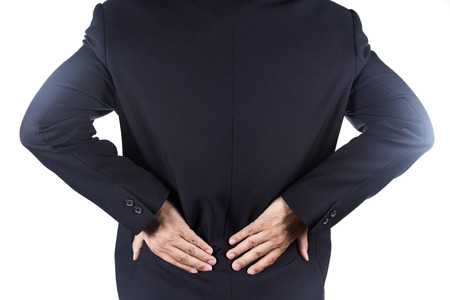 Businessman holding hands on his aching back on white background