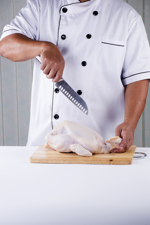 Chef prepared chopping raw chicken before cookingの写真素材