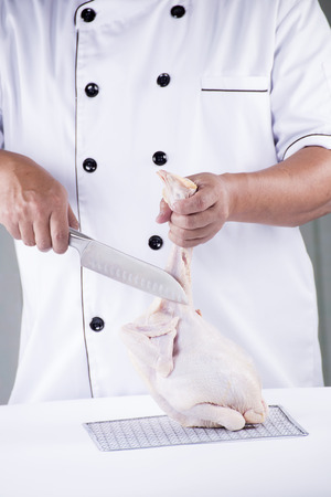 Chef prepared chopping raw chicken before cookingの写真素材