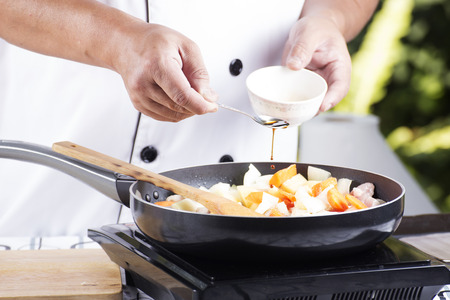 Chef putting seasoning sauce to the pan for cooking Japanese pork curry / cooking Japanese pork curry paste conceptの写真素材