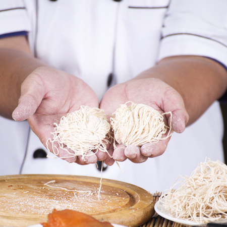 Chef present noodle before cooking / Cooking Noodle conceptの写真素材