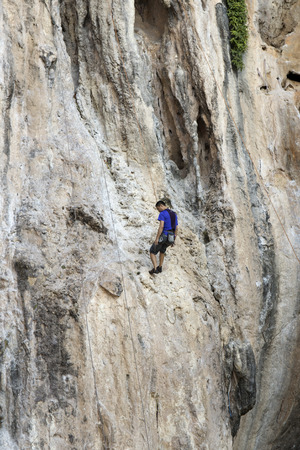 KRABI THAILAND  MARCH 28 2015: Rock climbers climbing the wall on Phra Nang beach One of the most popular rock climbing locations in Krabi Thailandのeditorial素材