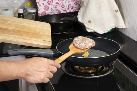 Chef putting beef Burger cooking in the pan  cooking Hamburger conceptの写真素材