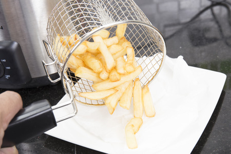 French Fried in the basket putting on the Plate
