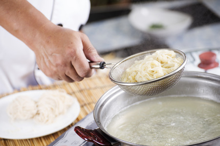 Chef holding colander with cooked Noodle  Cooking Noodle concept