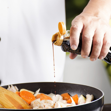 Chef pouring shoyu sauce to the pan for cooking Japanese pork curry  cooking Japanese pork curry paste conceptの写真素材
