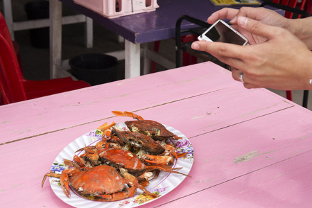 Take a photo before eat  stream crabs seafood on the plateの写真素材
