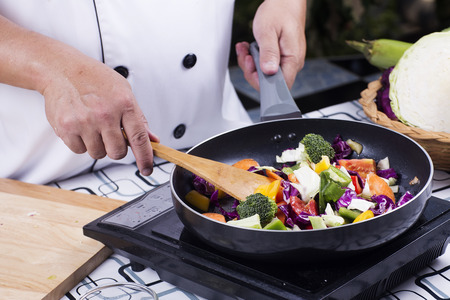 Chef cooking stir fried vegetable on the panの写真素材