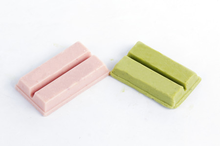 Matcha green tea and strawberry chocolate wafer on white backgroundの写真素材