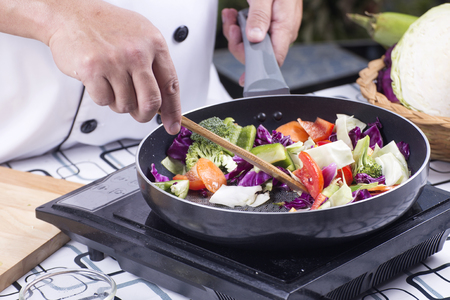 Chef cooking stir fried vegetable on the panの写真素材