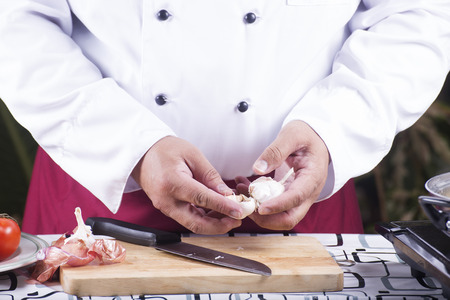 Chef peeling garlic with hand / cooking spagetti conceptの写真素材