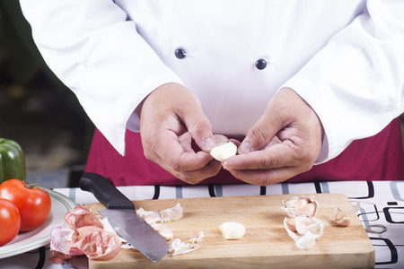 Chef peeling garlic with hand / cooking spaghetti conceptの写真素材