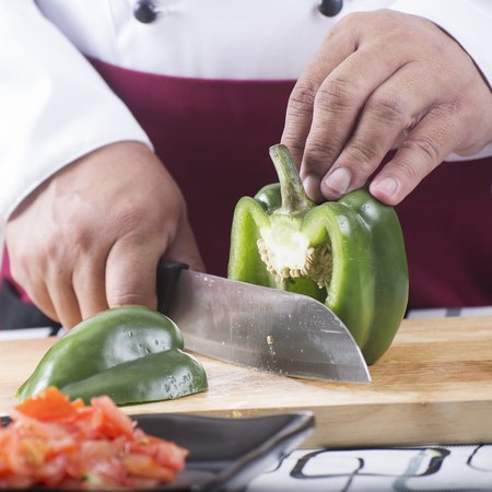 Chef cutting green bell pepper with knife before cooking / cooking spaghetti conceptの写真素材