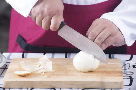 Chef cutting onion with knife / cooking spaghetti conceptの写真素材