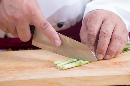 Chef slicing leak on wooden broad / Cooking Pad Thai concept