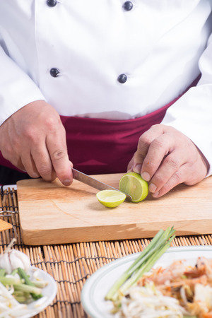 Chef slicing Lime for decorated Pad Thai  / cooking Pad Thai conceptの写真素材