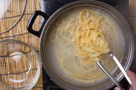 Chef cooking spaghetti in the pan / cooking spaghetti conceptの写真素材
