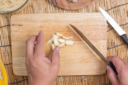 Chef  slicing garlic with knife / cooking spaghetti conceptの写真素材