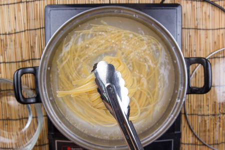 Chef cooking spaghetti in the pan / cooking spaghetti conceptの写真素材