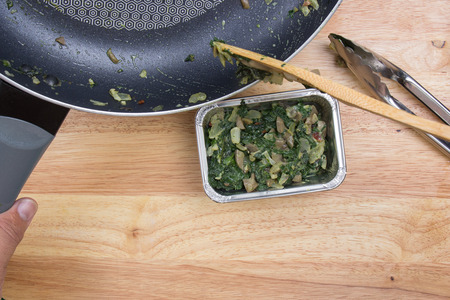 Putting cooking spinach to box / cooking Baked spinach conceptの写真素材