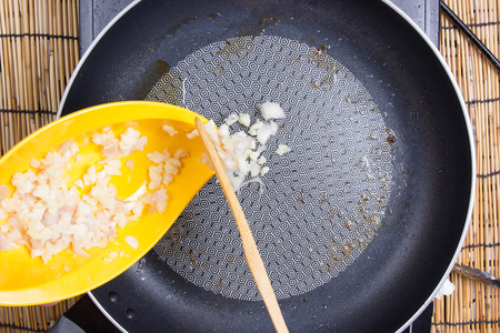 Chef putting garlic and onion to the pan / cooking spaghetti conceptの写真素材