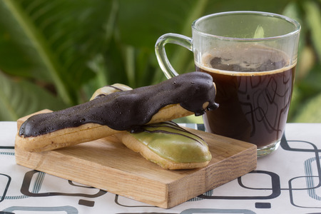 Green Tea and chocolate coating Eclair and black coffee