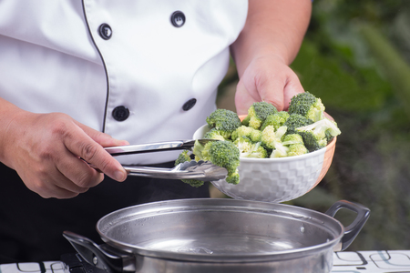 Chef putting broccoli hot water with tongs / Stir fry Broccoli conceptの写真素材
