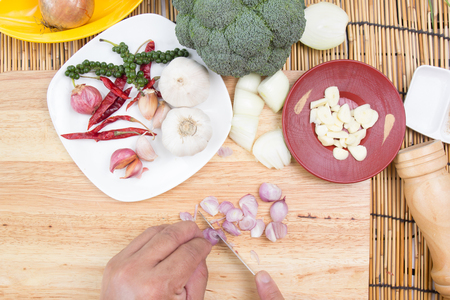 Chef slicing red onion on wooden broad / cooking spicy spaghetti conceptの写真素材