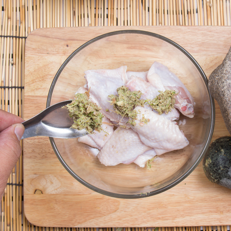Chef putting seasoning to chicken wings for cooking / cooking fried chicken wings conceptの写真素材