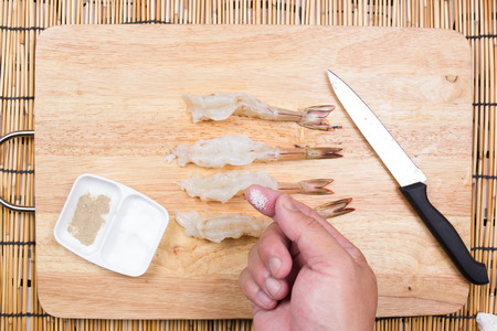 Chef cooking raw shrimp with salt and pepper / Cooking Tempura Udon conceptの写真素材