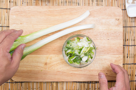 Chef putting slice of scallion to cup / Cooking Tempura Udon conceptの写真素材