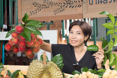 Asian woman with tropical fruit in the marketの写真素材