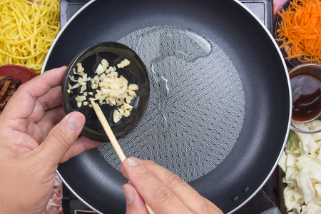 Chef putting minced garlic for cooking Yakisoba / cooking Yakisoba (Fried Japanesed noodle) conceptの写真素材