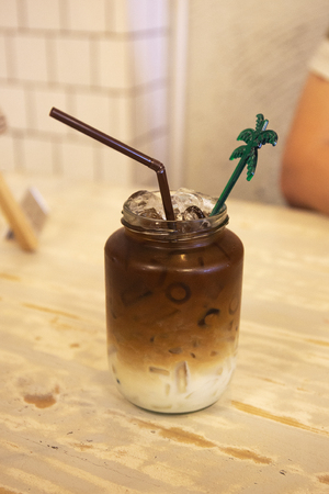 Iced coffee with milk in jar on the tableの写真素材