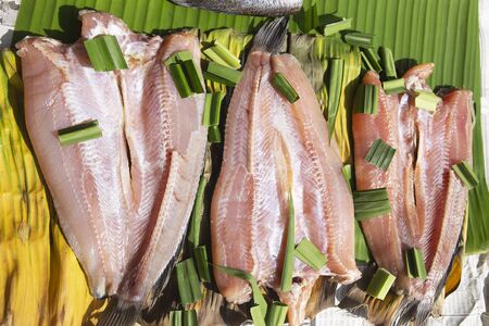 Set of sun dried gourami fish on Banana leaf / Salted gourami fish for Thai food preservationの写真素材