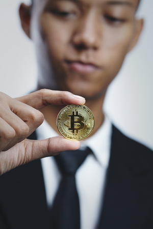 Asian Businessman Holding Bitcoin Bright Background               の写真素材