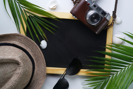 Sunglasses, Fedora Hat, Palm Leaf, Camera, Sea Shells and Blackboard Room for Text. Flat Lay Traveling Holiday Vacation Backgroundの写真素材