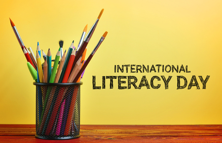 International Literacy Day. School Stationary in Basket on Wooden Table Yellow Backgroundの写真素材