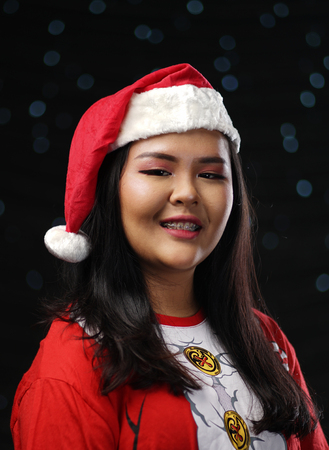Happy Asian Girl Wearing Santa Costume Christmas Dark Glow Bokeh Backgroundの写真素材
